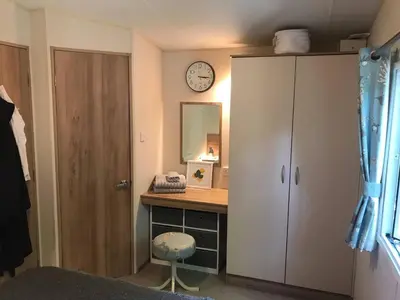 a bedroom with a desk and a clock on the wall at Badgers nestled in a cozy corner of the park in Wadebridge
