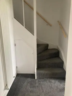 a stairwell with a staircase with a stair case at Newquay Beachcomber 2 Bedroom Apartment in Saint Columb Minor