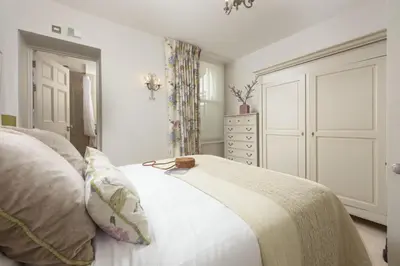 a bedroom with a bed and a dresser at Dolly's Plaice, Fowey in Fowey
