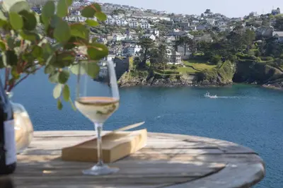 a glass of wine sitting on top of a table at Dolly's Plaice, Fowey in Fowey