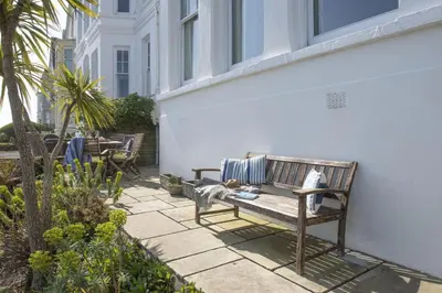 a bench sitting on the side of a building at Dolly's Plaice, Fowey in Fowey