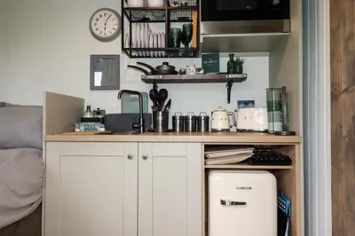 a kitchen with white cabinets and a counter top at The Highwood Hut in Liskeard