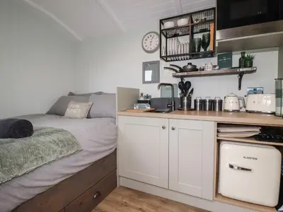 a small room with a bed and a counter at The Highwood Hut in Liskeard