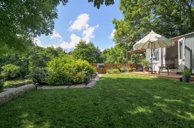 a yard with a patio and an umbrella at The Highwood Hut in Liskeard