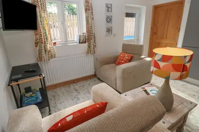 a living room with a couch and a table at The Stable in Penzance