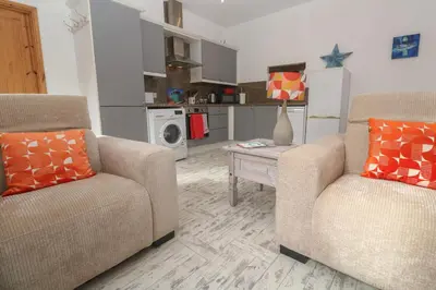 a living room with two chairs and a table at The Stable in Penzance