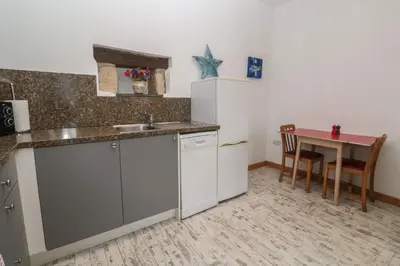 a kitchen with a table and a counter top at The Stable in Penzance