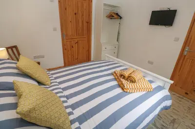 a bedroom with two beds with blue and white stripes at The Stable in Penzance