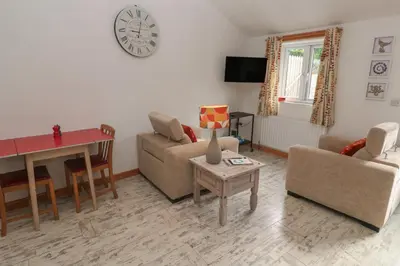 a living room with a couch and a table at The Stable in Penzance