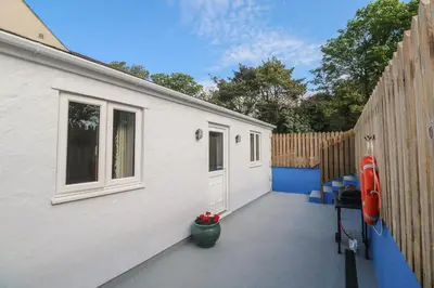 a white building with a fence and a patio at The Stable in Penzance