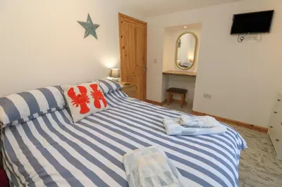a bedroom with a bed with blue and white stripes at The Packing House in Penzance