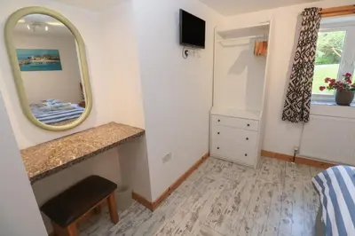 a small bedroom with a mirror and a sink at The Packing House in Penzance