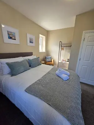 a bedroom with a large bed with two towels on it at Duke of Cornwall in St Austell