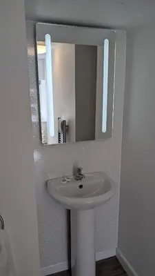 a bathroom with a white sink and a mirror at Duke of Cornwall in St Austell