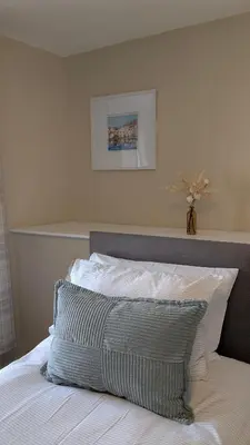 a bedroom with a bed with a gray and white pillow at Duke of Cornwall in St Austell