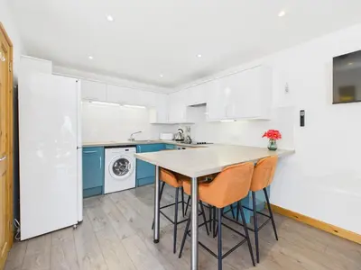 a kitchen with a table and chairs in it at Surf View by Signature Stays - Pool - Beach Access in Crantock