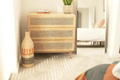 a wooden chest of drawers with a vase next to it at Kerrek Lodge in Falmouth