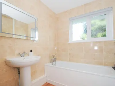 a bathroom with a sink and a bath tub and a window at Atlanta in Tintagel