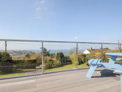 a view from the balcony of a house with a blue bench at Atlanta in Tintagel