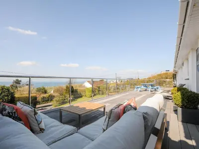 a couch on a balcony with a view of a road at Atlanta in Tintagel