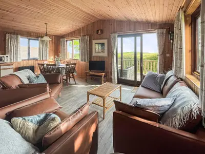 a living room with leather couches and a dining room at The Hut Hotel in Falmouth