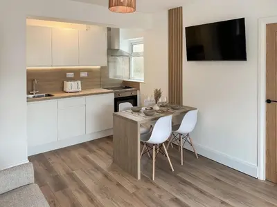 a kitchen with a table and chairs in a kitchen at Tide & Treth in Newquay