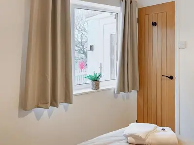 a bedroom with a window and a bed with a pillow at Tide & Treth in Newquay
