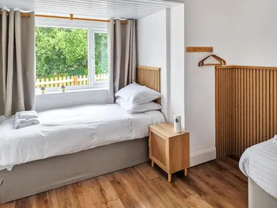 a small bedroom with a bed and a window at Tide & Treth in Newquay
