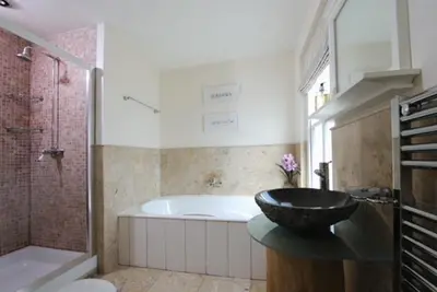 a bathroom with a tub and a sink and a bath tub at Cliff House, Cornwall in Padstow