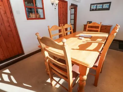 a wooden table and chairs in a room at Carolyns Cottage in Penzance