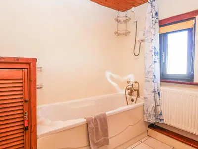 a white bath tub in a bathroom with a window at Carolyns Cottage in Penzance