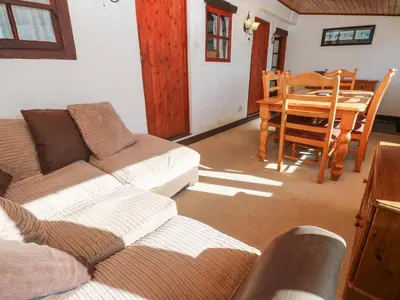 a living room with two couches and a dining room table at Carolyns Cottage in Penzance