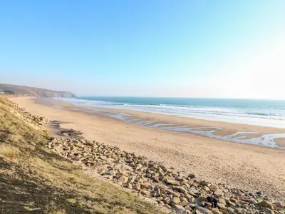 a beach with rocks and the ocean at Carolyns Cottage in Penzance