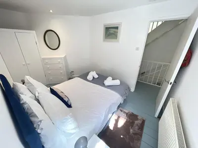 a small bedroom with a bed and a staircase at Chy Meor - a stonesthrow away from Porthmeor Beach in St Ives