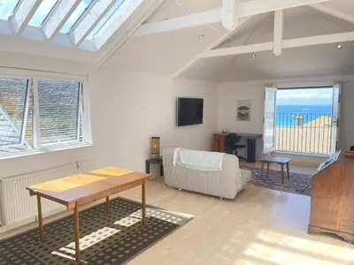 a living room with a table and a couch at Chy Meor - a stonesthrow away from Porthmeor Beach in St Ives