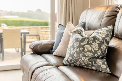 a brown leather couch with pillows on it in a living room at 4 Bed in St. Keverne oc-t31085 in Saint Keverne