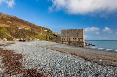 a building on a beach next to the ocean at 4 Bed in St. Keverne oc-t31085 in Saint Keverne