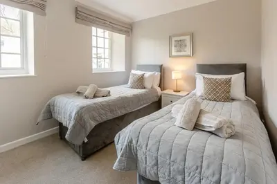 two beds in a room with two windows at 4 Bed in St. Keverne oc-t31085 in Saint Keverne