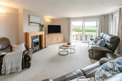 a living room with leather furniture and a tv and a fireplace at 4 Bed in St. Keverne oc-t31085 in Saint Keverne