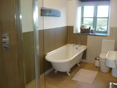 a bathroom with a tub and a shower and a toilet at The Barn At Collacott in North Petherwin