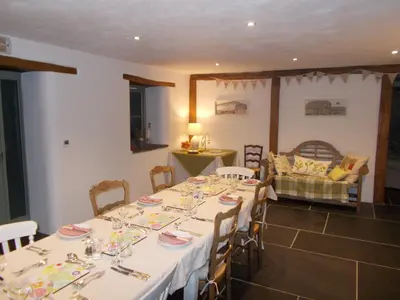 a dining room with white tables and chairs and a couch at The Barn At Collacott in North Petherwin