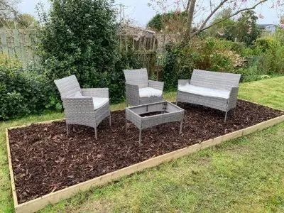 three chairs and a fire pit in a yard at Charming Chardan Cottage, Fowey in Fowey