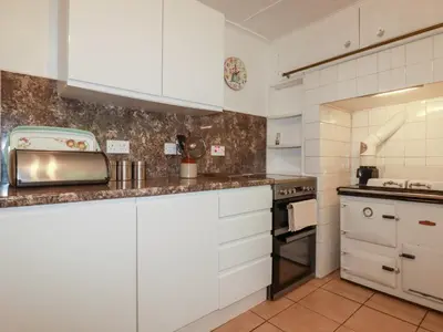 a kitchen with white cabinets and a stove at Nanvivian in Feock