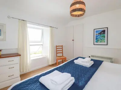 a bedroom with a bed with two towels on it at Nanvivian in Feock