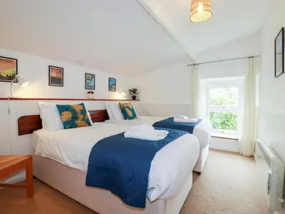 a bedroom with two beds and a window at Nanvivian in Feock