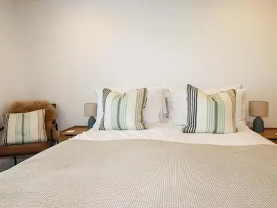 a bedroom with a white bed with pillows on it at 4 Ocean Gate in Newquay