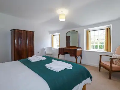 a bedroom with a bed with a mirror and a piano at Pennine in Truro