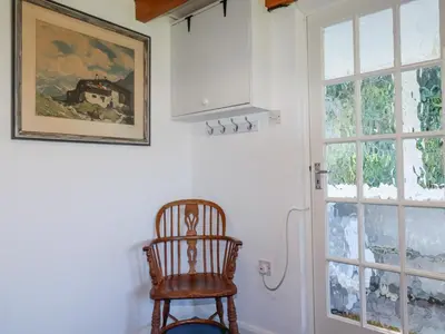 a wooden chair in a room with a window at Pennine in Truro