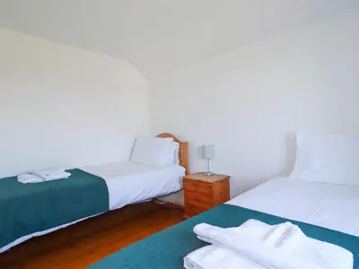 a bedroom with two beds and a nightstand with towels at Pennine in Truro