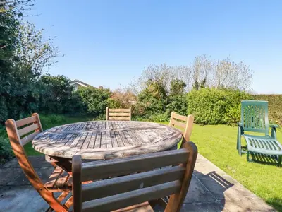 a wooden table with four chairs around it at Pennine in Truro